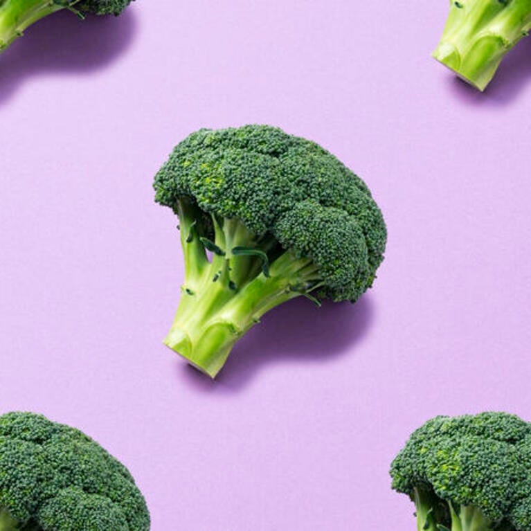 Broccoli in front of purple background