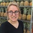 Wynter in front of shelves filled with pineapples